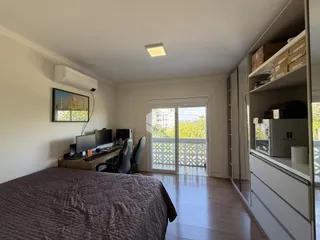 Quarto com vista para o exterior e porta de vidro.