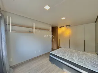 Quarto com piso de madeira e armários embutidos.