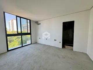 Uma sala vazia com grande janela e piso de concreto.