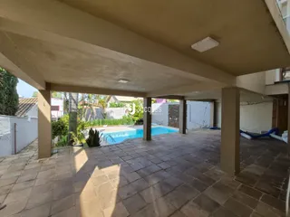 Área externa coberta com piso de tijolos e vista para a piscina em Lajeado, Brasil.
