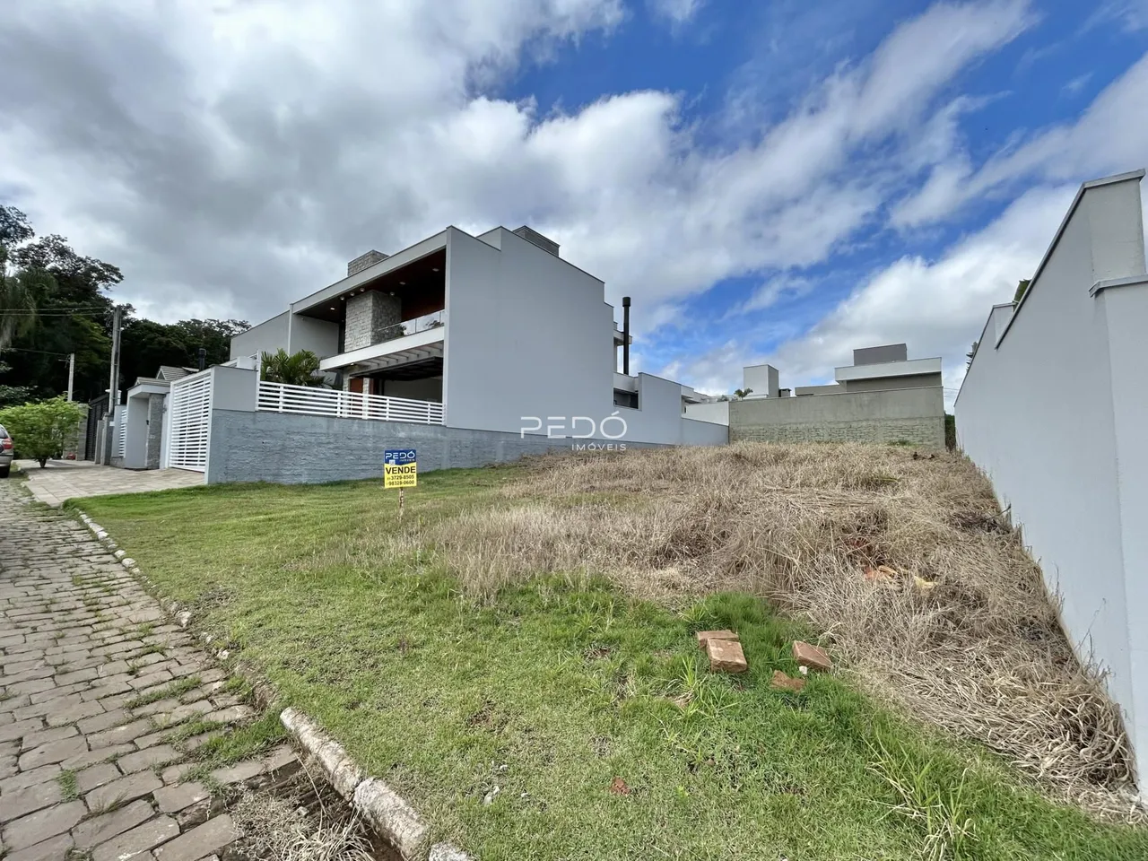 Fachada de uma residência moderna em Lajeado, Brasil, com jardim gramado na frente.