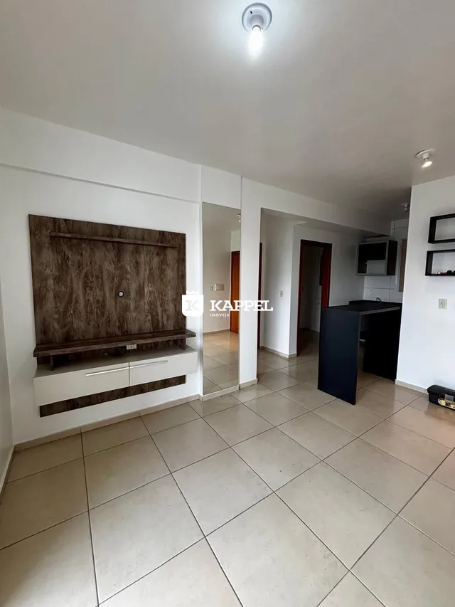 Uma sala de estar com painel de madeira escura e piso de cerâmica clara.