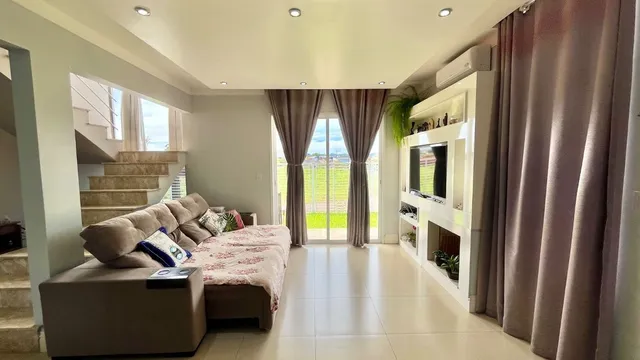 Sala de estar com sofá e vista para o campo aberto.