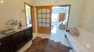 Passagem interna de um imóvel com paredes brancas e piso de cerâmica.