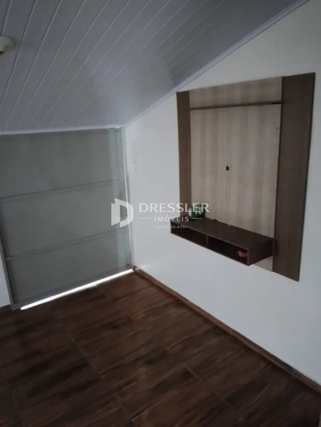 Foto de um ambiente interno com piso de madeira escura.