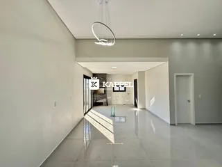 Ambiente amplo com piso polido e iluminação clara em um imóvel.