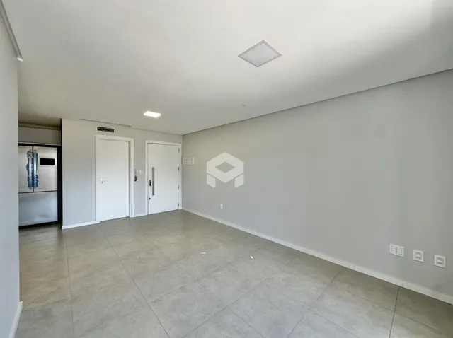 Ambiente interno de uma sala com piso de cerâmica e paredes brancas.
