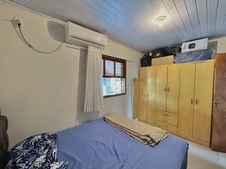 Quarto com cama e armários de madeira em um imóvel no Brasil.