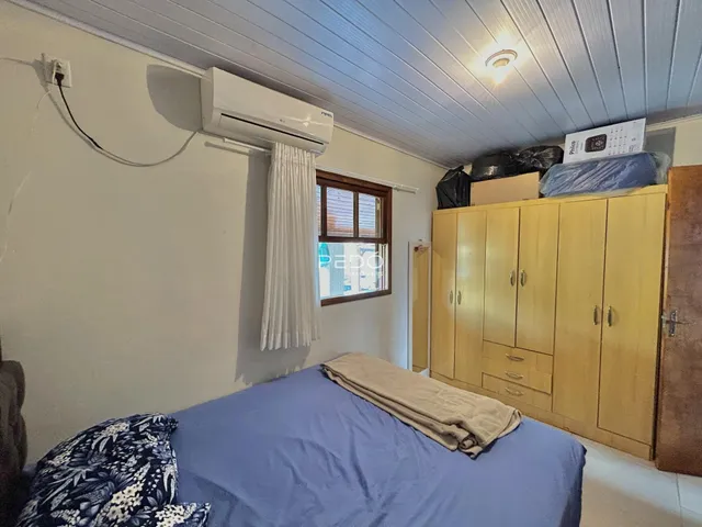 Quarto com cama e armários de madeira em um imóvel no Brasil.