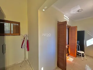 Hall de entrada com porta de madeira visível.