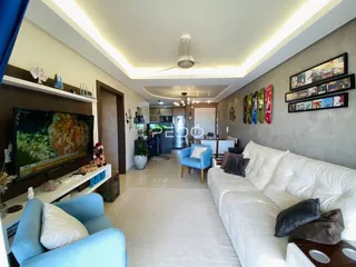 Sala de estar ampla com sofá branco e decoração moderna.