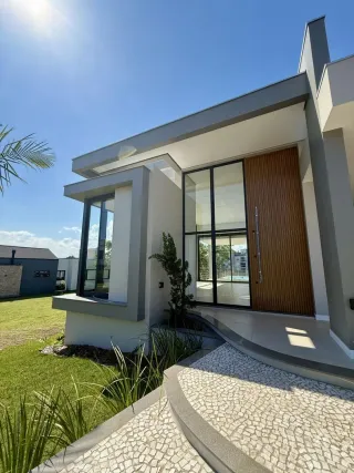 Fachada moderna de uma residência em Lajeado, Brasil, com jardim e calçada.