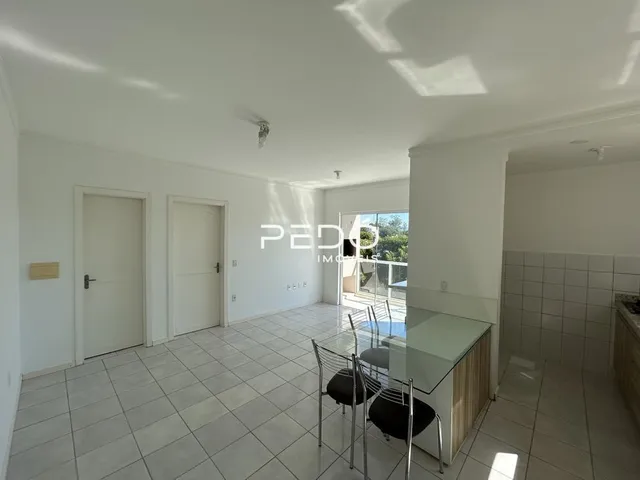 Vista interna de um ambiente com piso de cerâmica e portas brancas.
