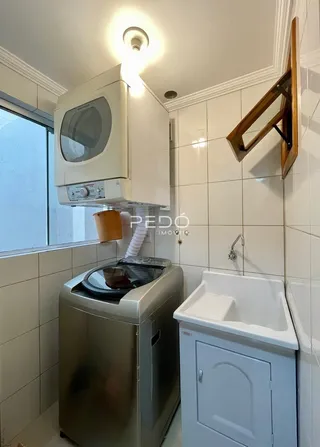 Vista de uma área de cozinha com fogão e pia em um imóvel.