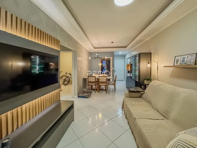 Sala de estar com sofá e televisão em um apartamento.