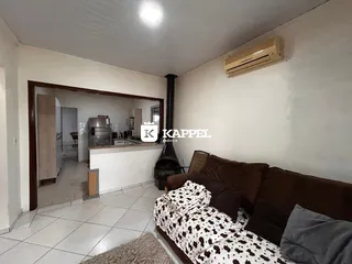 Sala de estar com sofá e vista para a cozinha.
