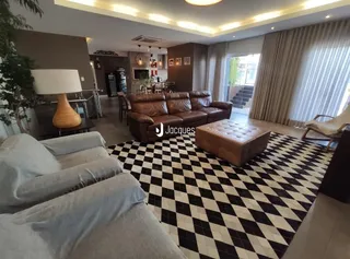 Sala de estar com sofá de couro marrom e piso xadrez preto e branco.