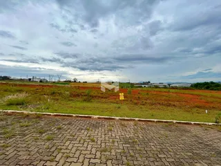 Vista de uma área de campo com vegetação e horizonte sob um céu nublado.