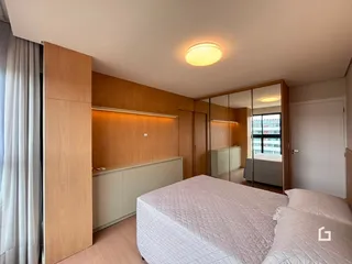 Quarto com armários de madeira e cama grande.