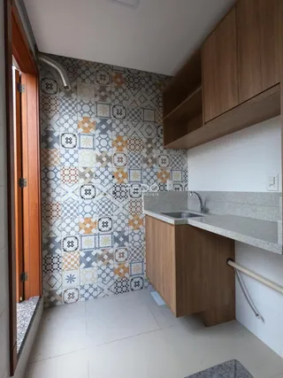 Foto de um banheiro com revestimento de azulejos decorativos e bancada de madeira.