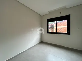 Vista interna de um ambiente com paredes brancas e piso cinza.