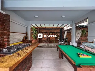 Vista de uma área de cozinha e estar com piso de madeira em uma propriedade em Lajeado.