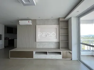 Ambiente interno de uma sala com painel decorativo e estante embutida.