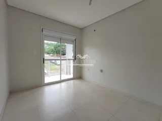 Ambiente interno de uma sala com piso claro e porta de vidro.