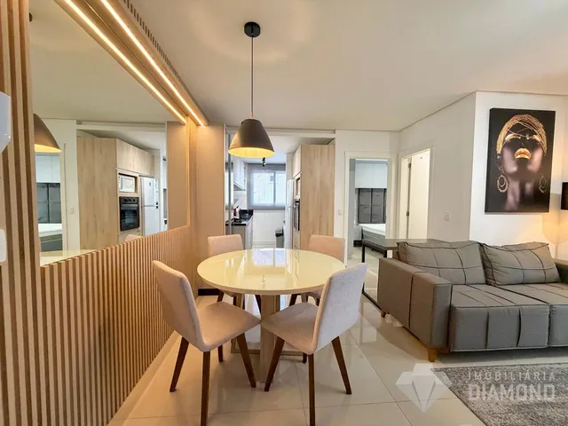 Uma sala de jantar moderna com mesa redonda e cadeiras claras.
