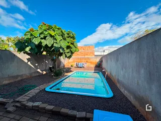 Vista de uma piscina externa em um pátio cercado por muros.