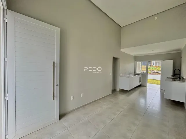 Vista interna de um corredor com paredes cinzas e piso de cerâmica.