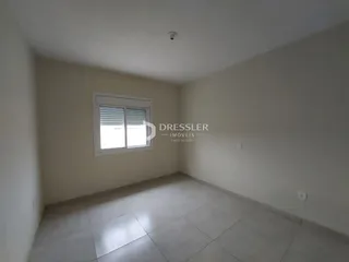 Ambiente interno de uma sala com piso de cerâmica e janela.