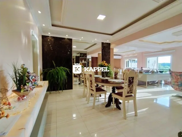 Sala de jantar com mesa e cadeiras em um ambiente claro com piso de cerâmica.