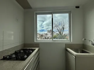 Vista interna de uma cozinha com janela para o exterior.