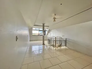 Corredor com paredes brancas e piso de cerâmica claro.