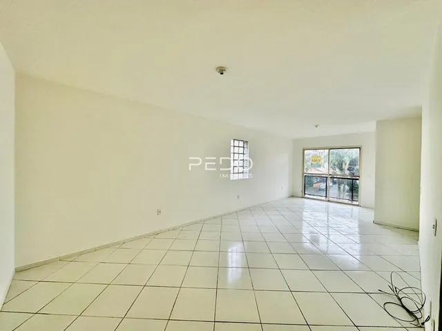 Interior de uma sala ampla com piso de cerâmica branca.