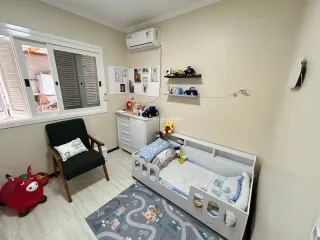 Quarto com cama e armários brancos em ambiente interno.