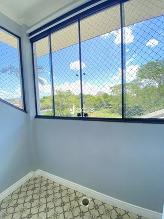 Vista interna de um cômodo com piso estampado e grande janela.