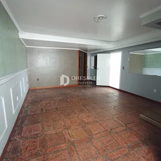 Vista interna de um ambiente com piso de ladrilhos avermelhados.