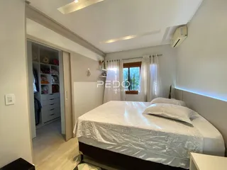 Quarto com cama e armário aberto.