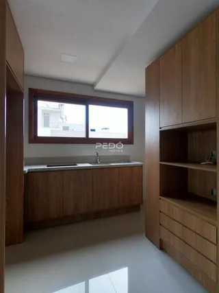 Foto de uma cozinha com armários de madeira e janela.