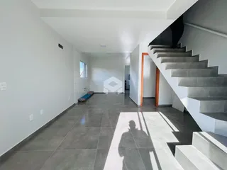 Vista de um corredor interno com piso de cerâmica e escadaria.