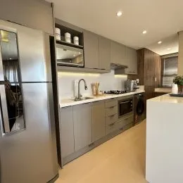 Foto de uma cozinha moderna com armários e eletrodomésticos em um imóvel.
