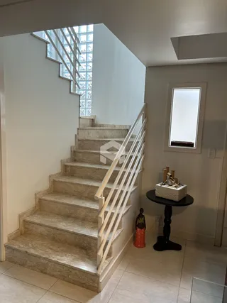 Escadaria de pedra com corrimão branco em um ambiente interno.