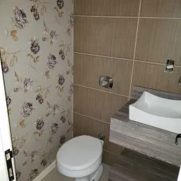 Banheiro com revestimento de parede estampado.