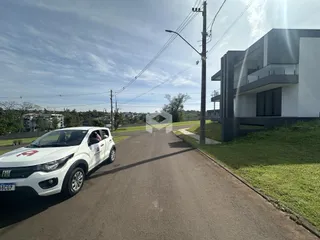 Vista da fachada de uma casa moderna em Lajeado, Brasil, ao lado de uma rua asfaltada.