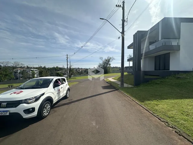 Vista da fachada de uma casa moderna em Lajeado, Brasil, ao lado de uma rua asfaltada.