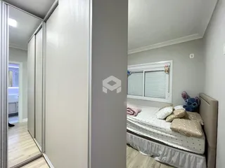 Quarto com janela e armário em ambiente residencial.