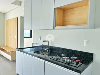 Foto de uma cozinha moderna com armários brancos e bancada escura.