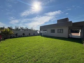 Fachada de uma residência com grande gramado verde.